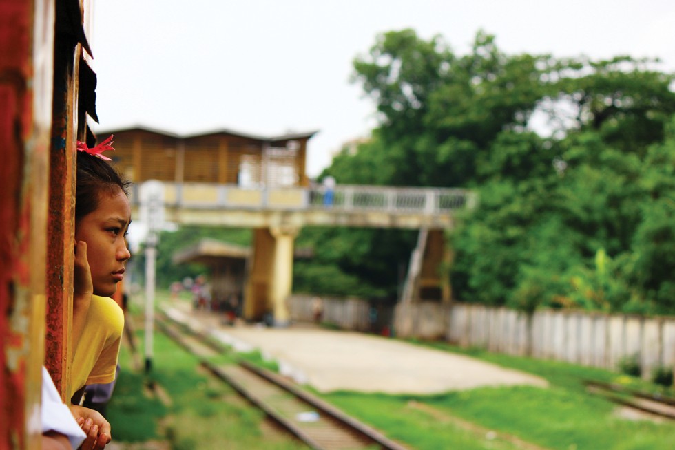 a young commuter gazes at the passing scenery on the way to a market outside of yangon.