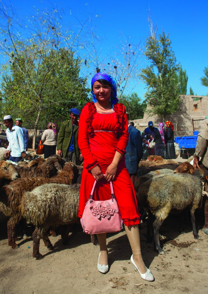 Yarkand: Pretty girls stroll among the beasts. Their two eyebrows are joined, a sign of beauty among the Uighurs.