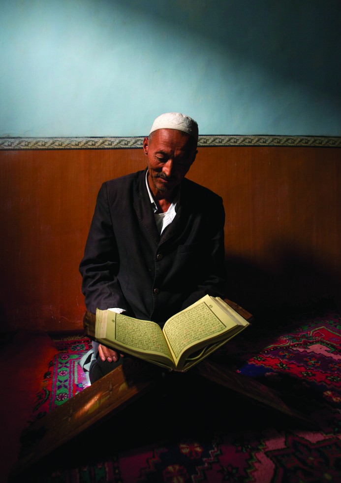 Mahmud, a carpenter in Keriya, retires to a corner of the room, opens a Koran, places it on a wooden trestle under the soft light of a high window, and begins to read.