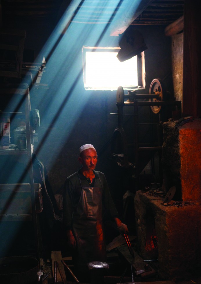 Mahmud, a carpenter in Keriya, retires to a corner of the room, opens a Koran, places it on a wooden trestle under the soft light of a high window, and begins to read.