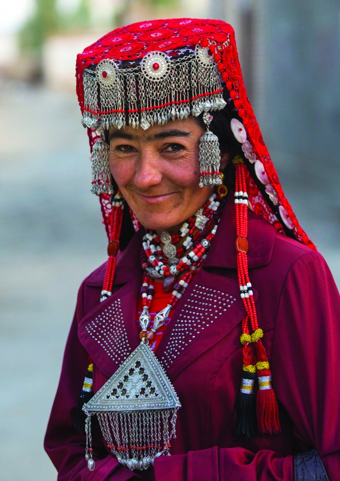 Tajik women wearing colourful and embroidered jewellery, long braids, layered necklaces, earrings and ornaments carved in silver. I wonder where the wedding is. No wedding – they dress like this every day.