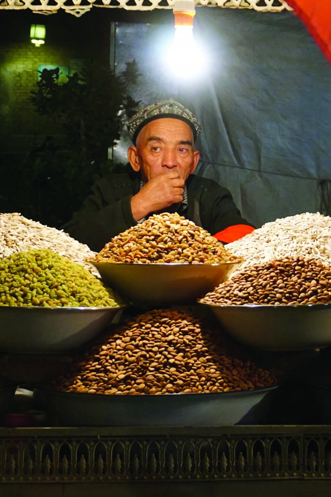 At the old town night market, a Uyghur vendor nibbles from piles of raisins, dates and nuts. To enter the night market, Uyghurs must pass through a series of police checks, including metal detectors, ID checks and frisking; foreigners and Han Chinese can freely enter. 77 Elite+ Magazine www.eliteplu