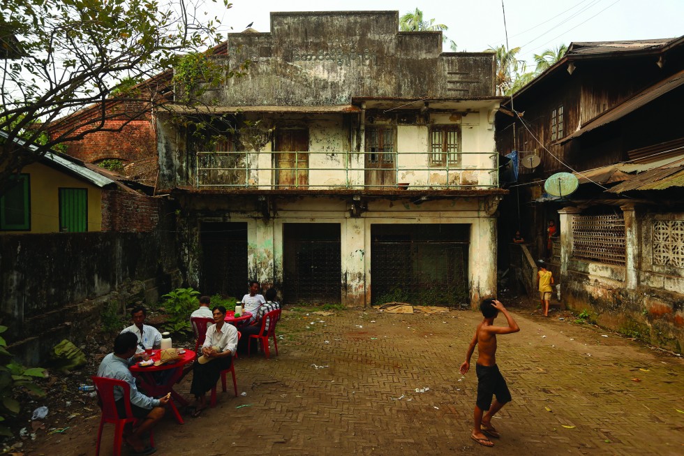 Drinking tea in front of the abandoned Aung Theit Hti Cinema in Myaungmya, Irrawaddy Region, Myanmar.