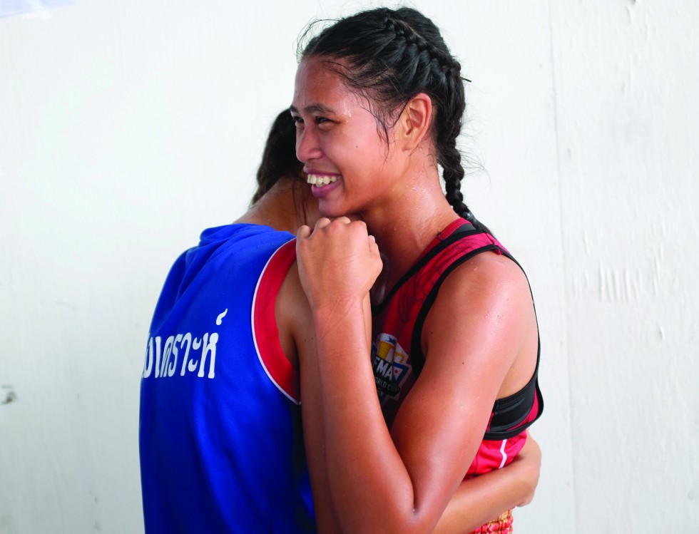 Two boxers embrace after a bout. The woman in red won the bout on points and would move on to qualify for the Thai national team.