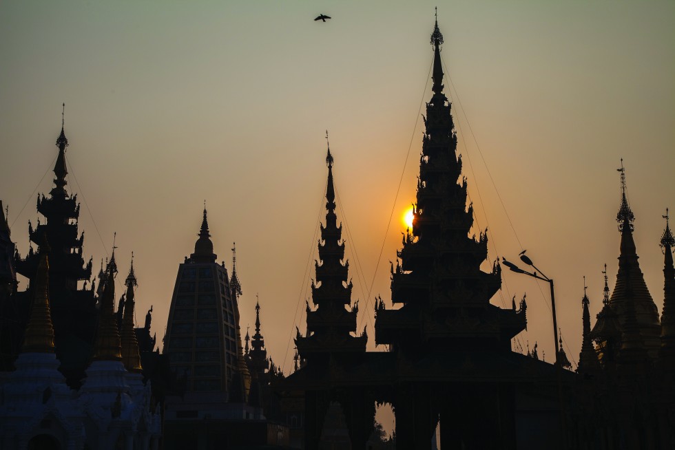 Yangon, Myanmar: When dawn layers the roofs of temples, I stretch my legs to find you pausing at a door, looking out.