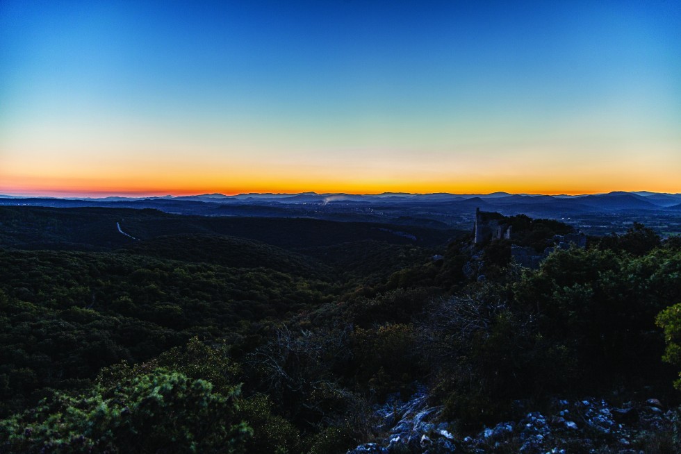 The ruins of a medieval castle, the Chateau d’Alègre, at sunset.