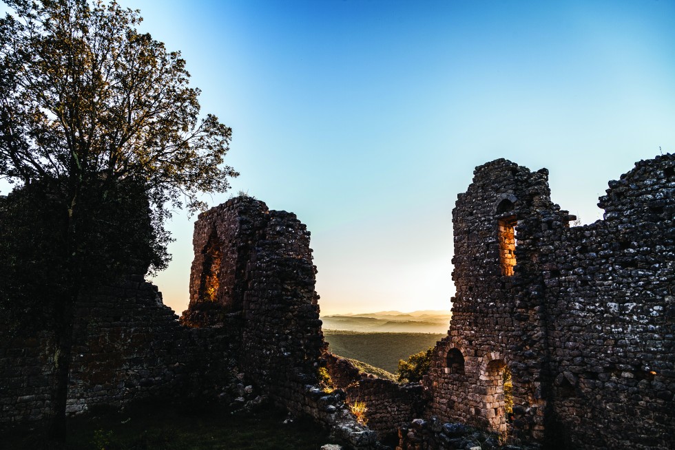The ruins of a medieval castle, the Chateau d’Alègre, at sunset.