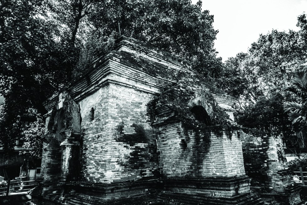 A chedi over the centuries becoming absorbed by the nature around it. A samlor driver taking a break along the city moat.