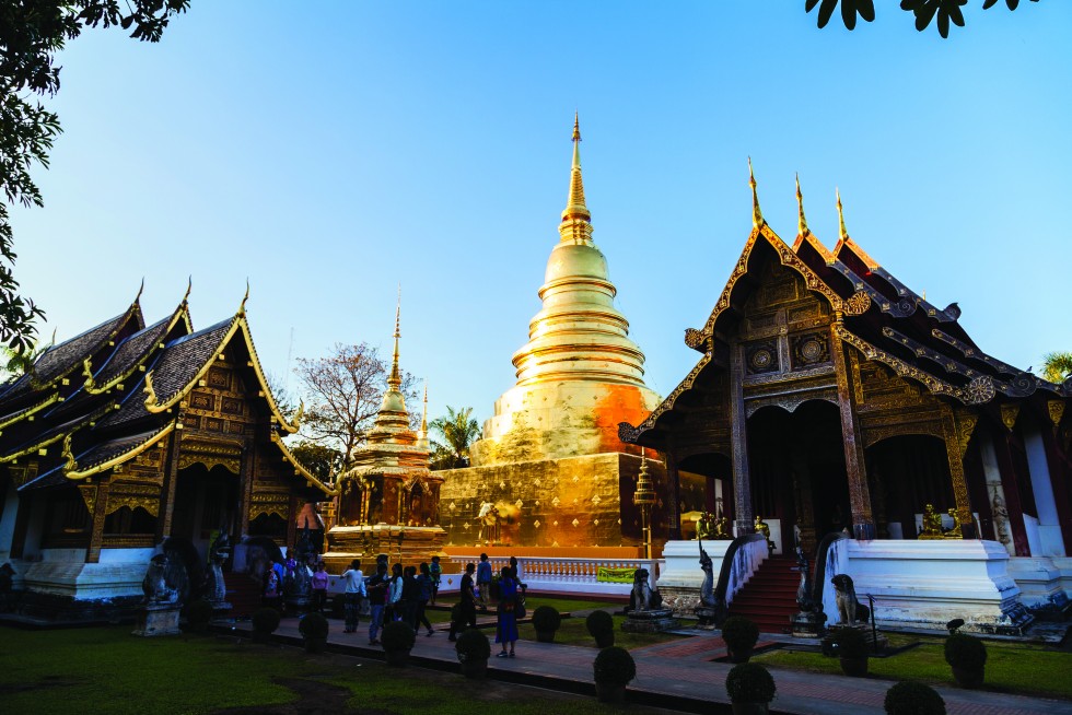 The northern style architecture of Viharn Lai Kam at Wat Phra Singh, dating from 1345. Below, the chedi at Wat Phan Tao at nightfall. The viharn, not shown, is constructed of teak.