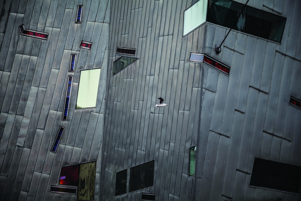 A gull flies across the ACMI Arts Centre; and the train and meeting hub of Flinders Street Station.