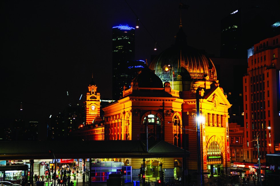 A gull flies across the ACMI Arts Centre; and the train and meeting hub of Flinders Street Station.