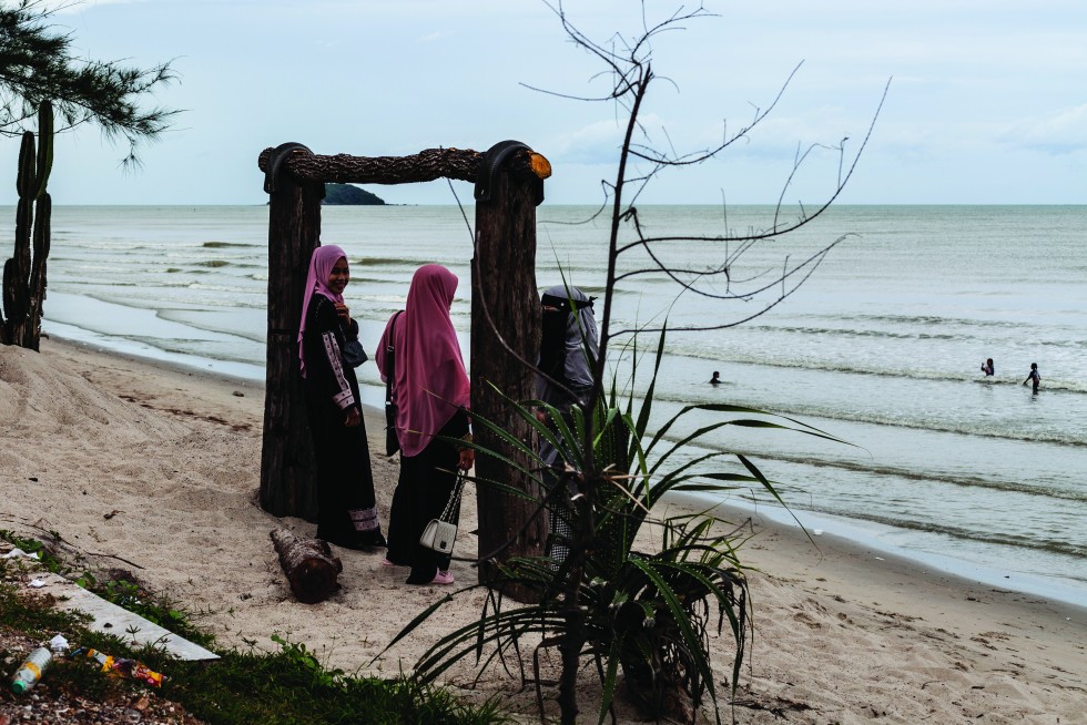 Girls meet along the shore and a fishing boat waits for its next adventure.