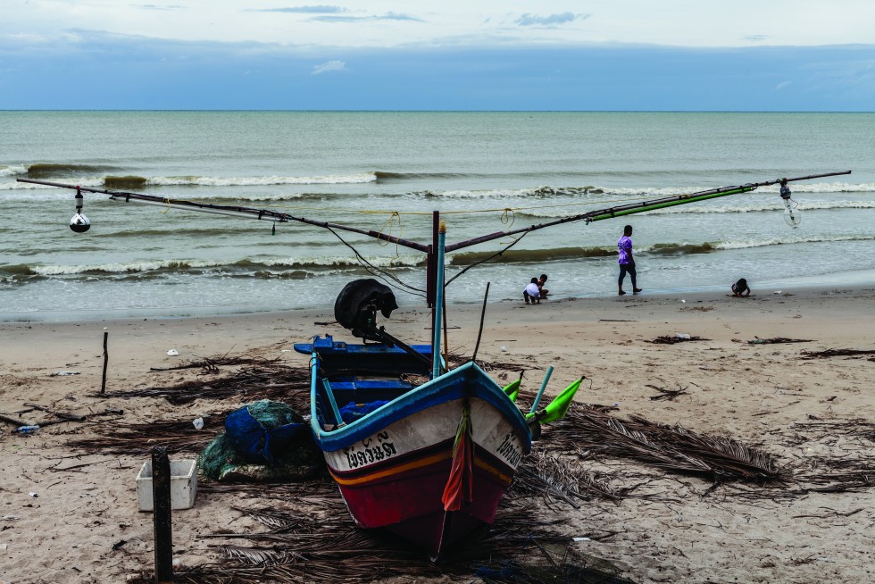 Girls meet along the shore and a fishing boat waits for its next adventure.